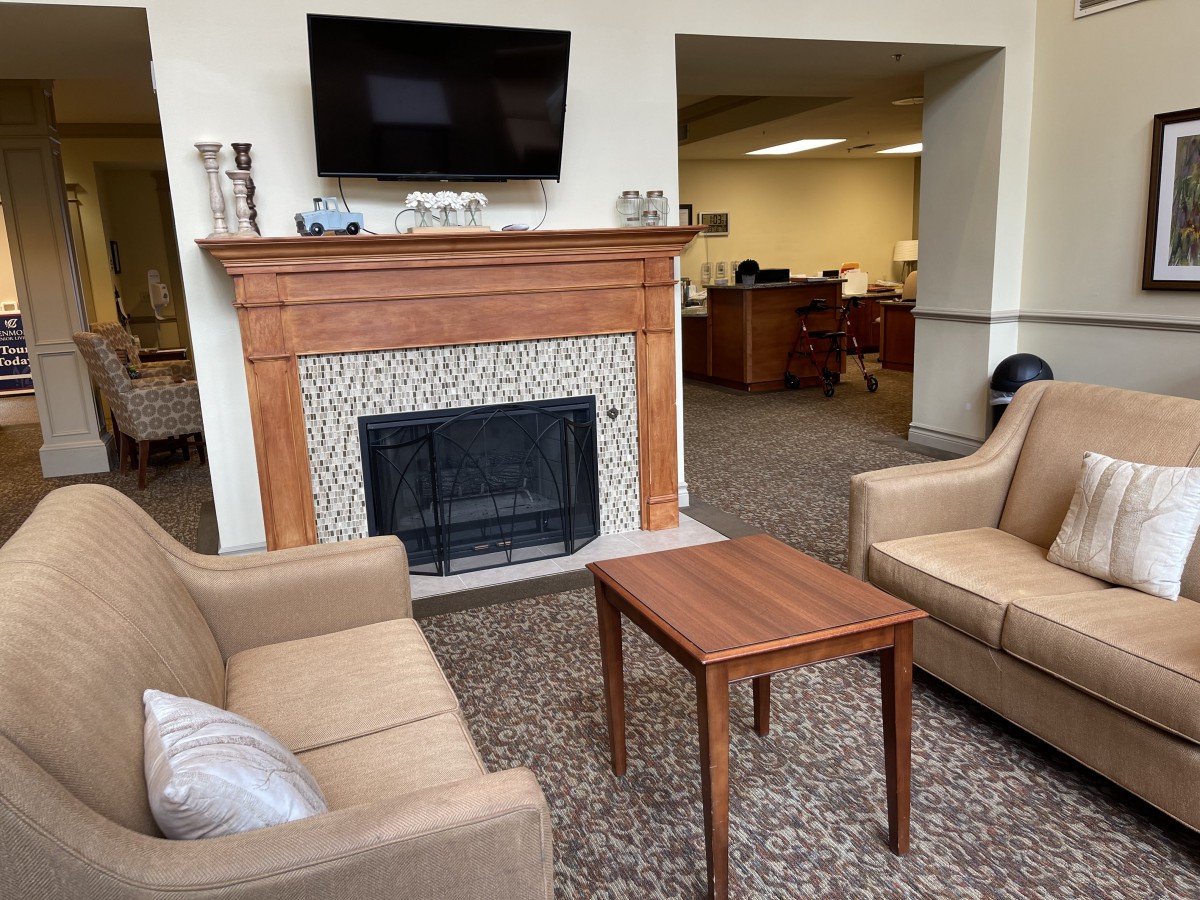A cozy office lounge area with a fireplace, television, and comfortable seating.