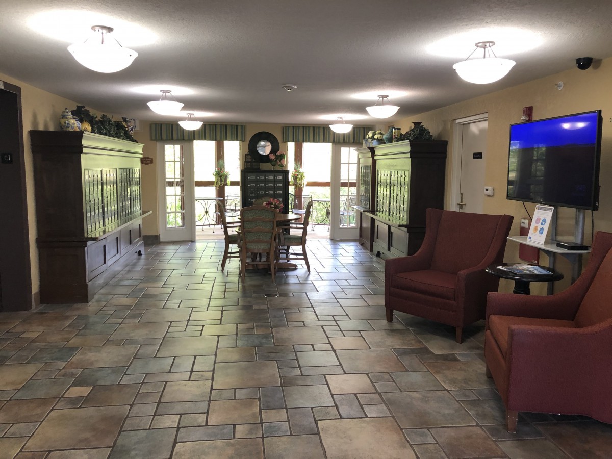 A cozy interior with seating arrangements and large aquariums lining the walls.