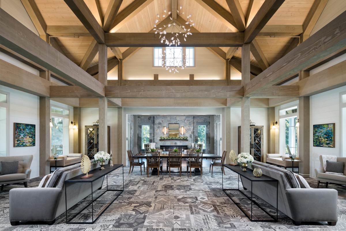 A luxurious and spacious living room with wooden beams and a decorative chandelier.