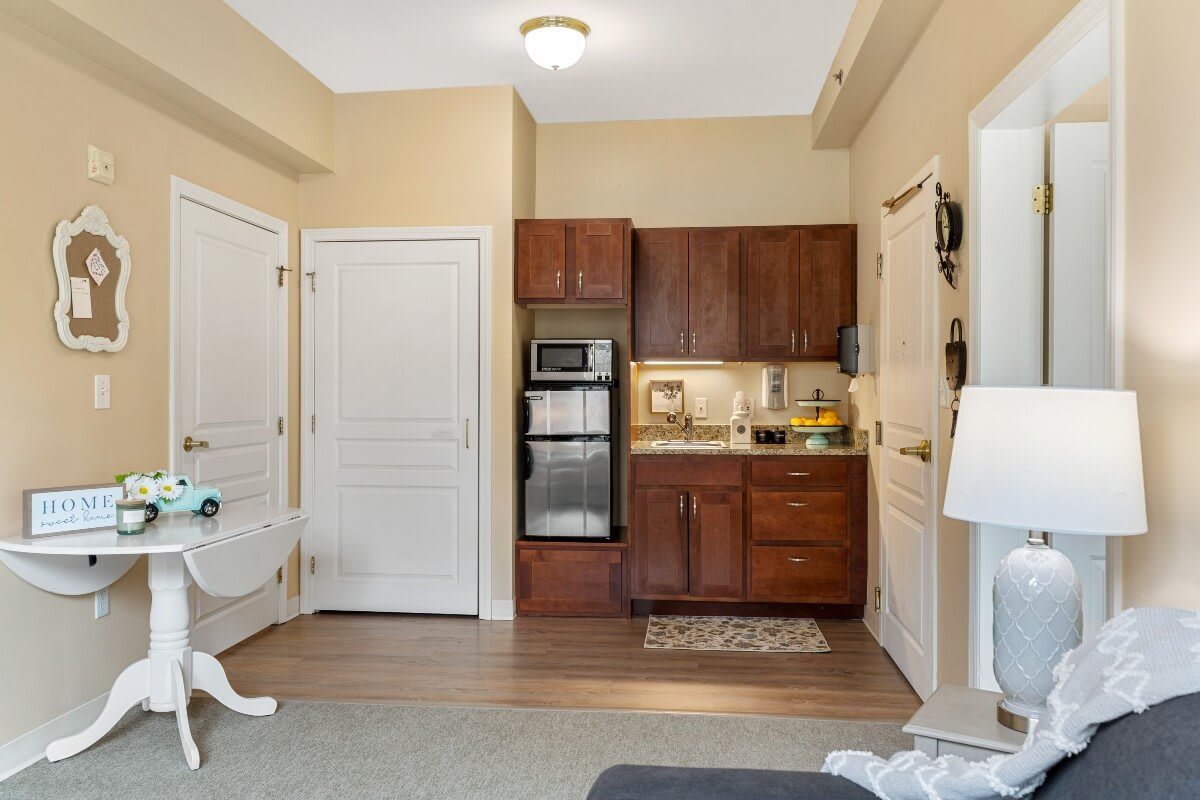 A compact kitchenette in an apartment with wood cabinets, an oven, and a microwave.