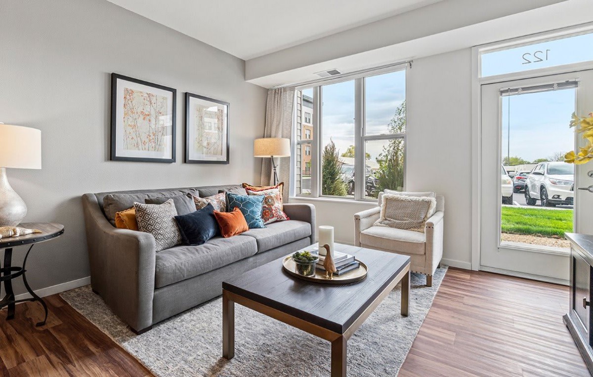 A cozy living room with a comfortable sofa and stylish decor, featuring large windows that let in plenty of natural light.