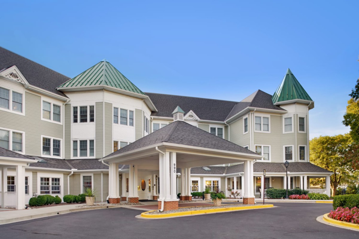 A modern residential building with a covered entrance and distinctive roof design.