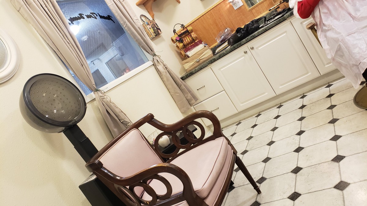 A cozy kitchen with a vintage chair and classic white cabinets.