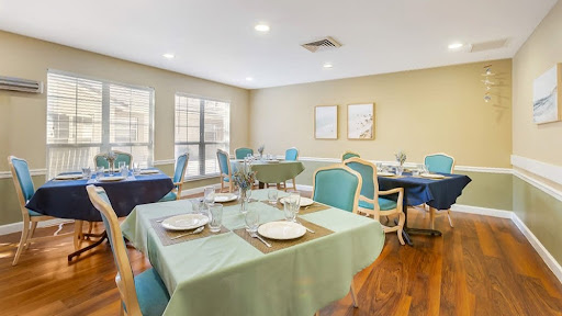 A stylish dining area featuring elegantly set tables with a calming green and blue color scheme.