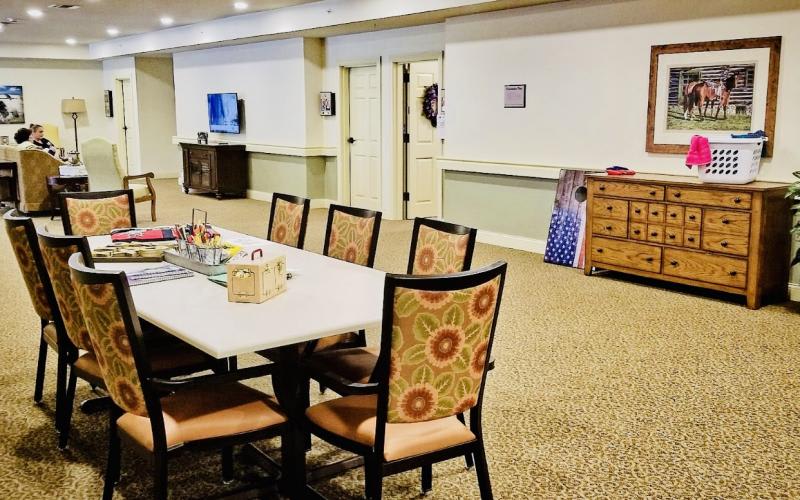 A meeting room with a table and several chairs, a television, and decorative elements.