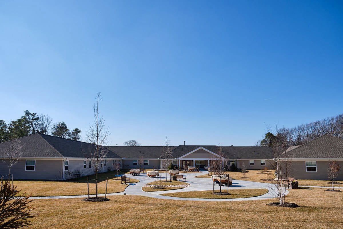 A residential building with a landscaped lawn and clear blue sky.