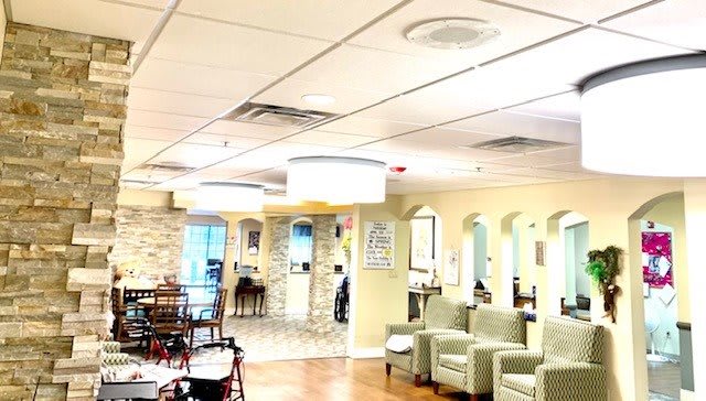 A bright and welcoming lobby or waiting area with chairs and tables.