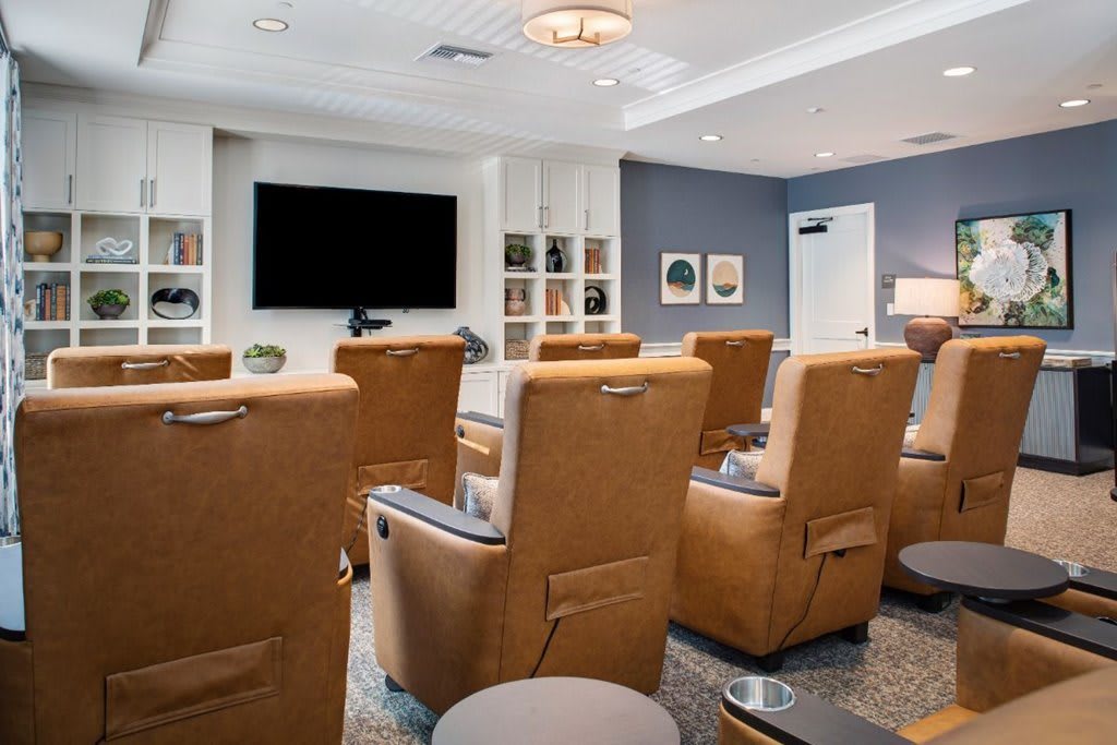 A modern home theater with comfortable recliner chairs and a large TV.