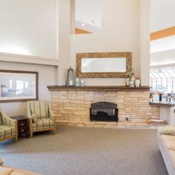 A cozy living room with a stone fireplace and comfortable seating.