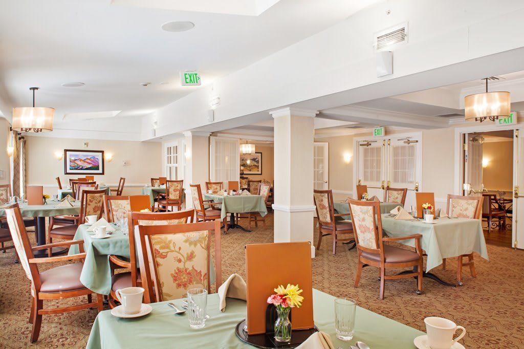 A well-lit dining room featuring elegantly arranged tables and chairs.