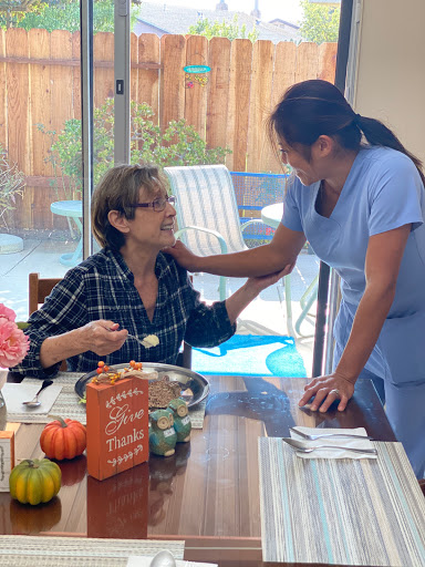 A warm moment shared between a caregiver and an older adult during a meal.