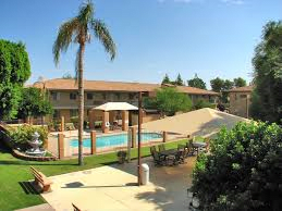 A sunny day at a resort with a pool and palm trees.