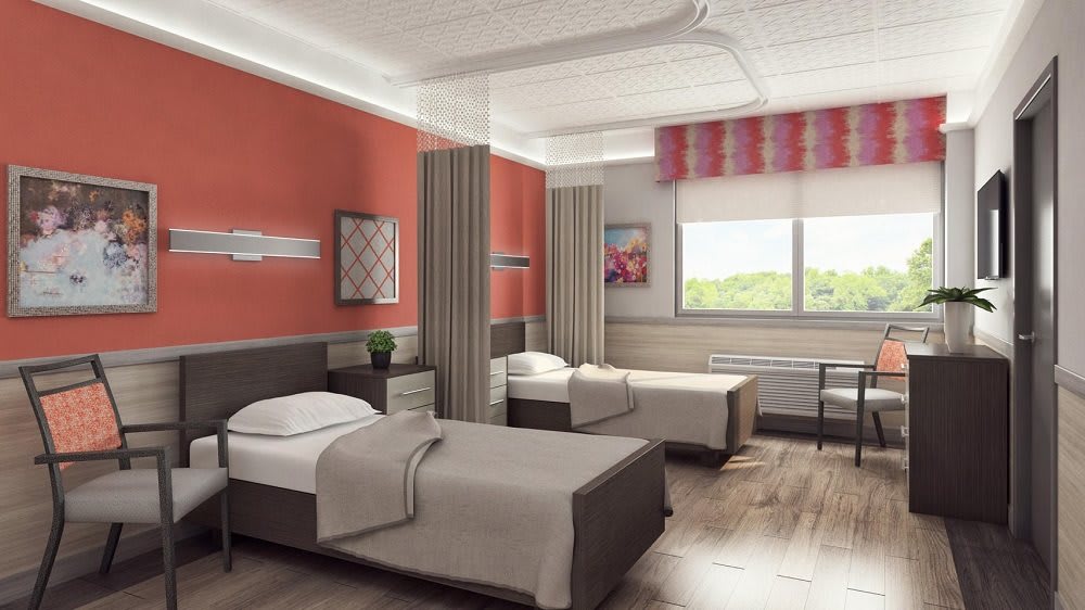 A modern hospital room with twin beds and natural light.