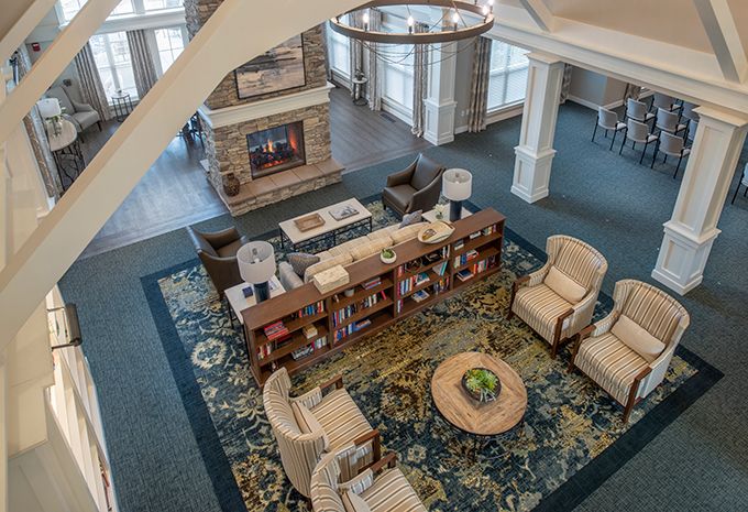 An inviting living room with comfortable seating and a central bookshelf, adorned with a patterned carpet.
