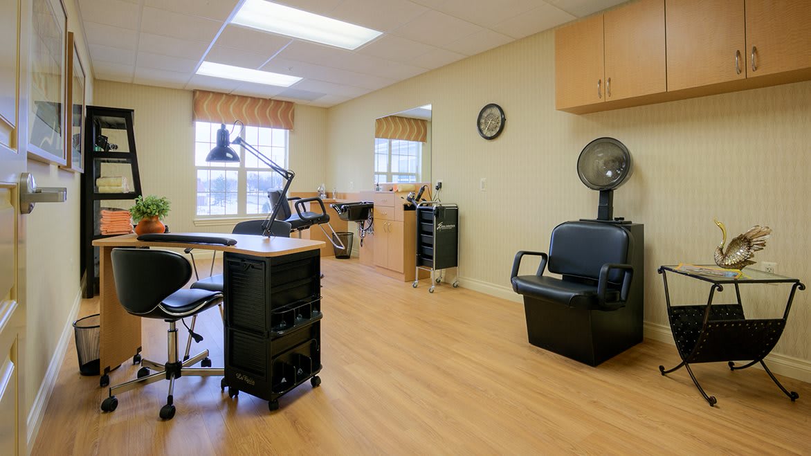 A tidy hair salon interior featuring a workstation, chairs, and styling tools.