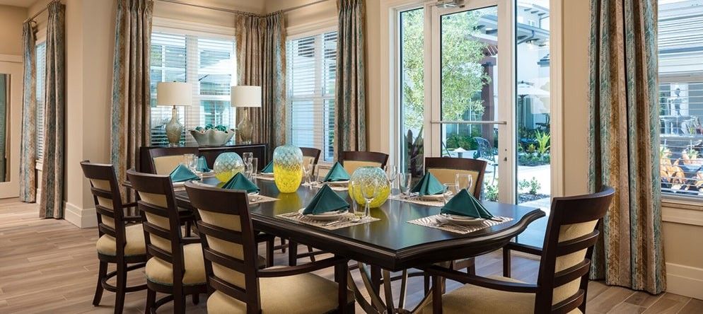A beautifully set dining table with a modern interior and ample natural light.