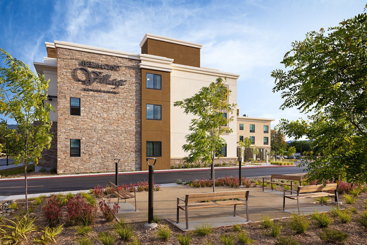 A view of a modern hotel building with a landscaped exterior.