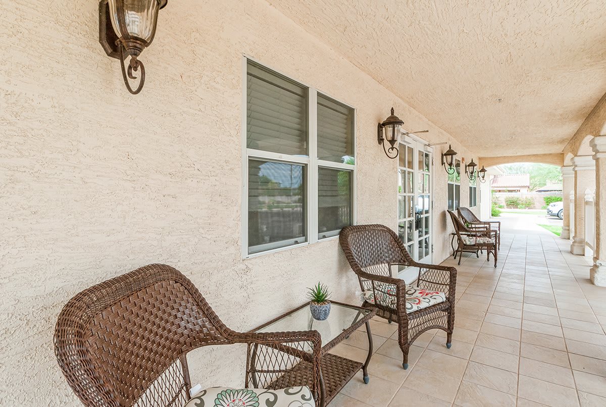 A cozy porch with wicker furniture and decorative lighting fixtures.