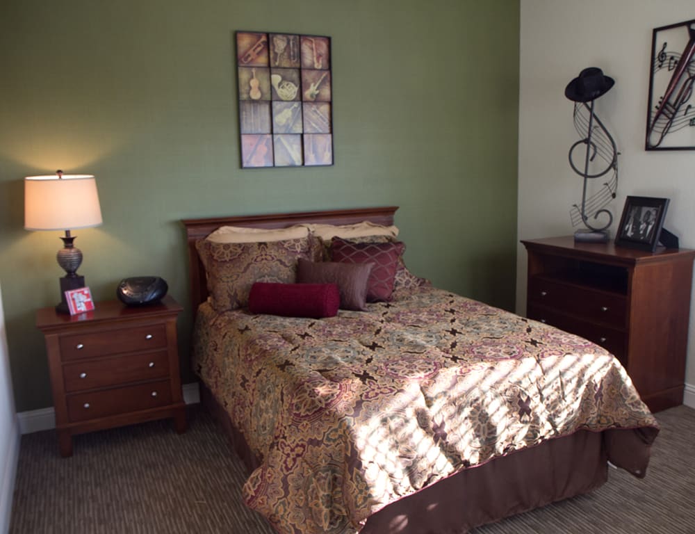 A cozy bedroom with a neatly made bed, side tables, and decorative items.