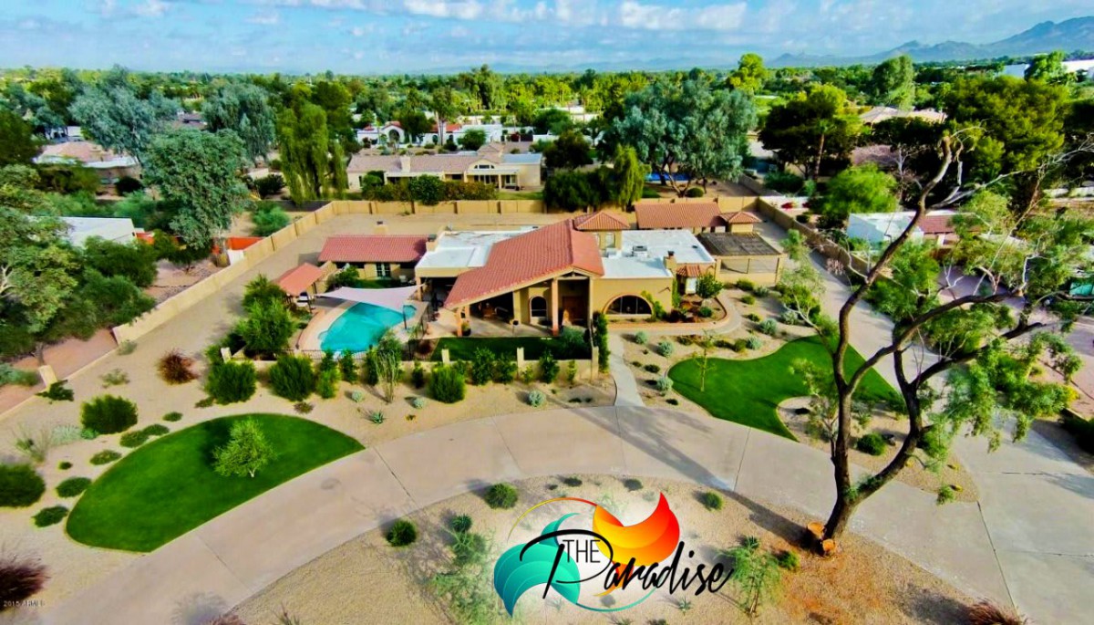 Aerial view of a luxurious resort with a pool and landscaped gardens.