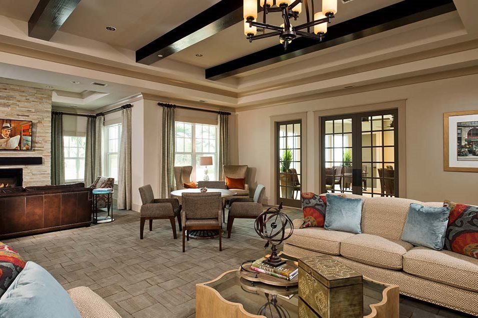 A spacious and elegantly designed living room with comfortable seating and a chandelier.