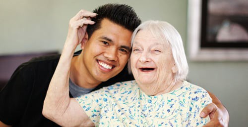 A joyful moment shared between a young man and an elderly woman.
