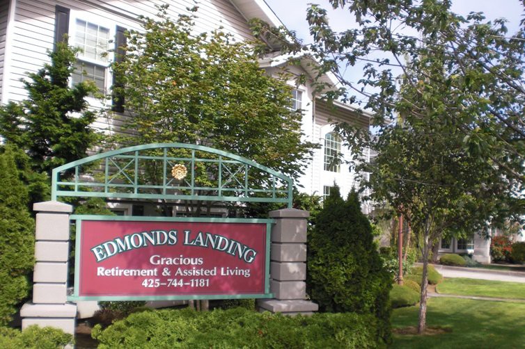 Sign for Edmonds Landing, a retirement and assisted living community, surrounded by greenery.