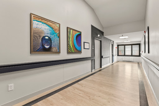 A well-lit hallway featuring vibrant abstract paintings.
