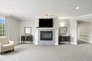 A spacious living room with a fireplace and wall-mounted TV, featuring elegant decor and furniture.