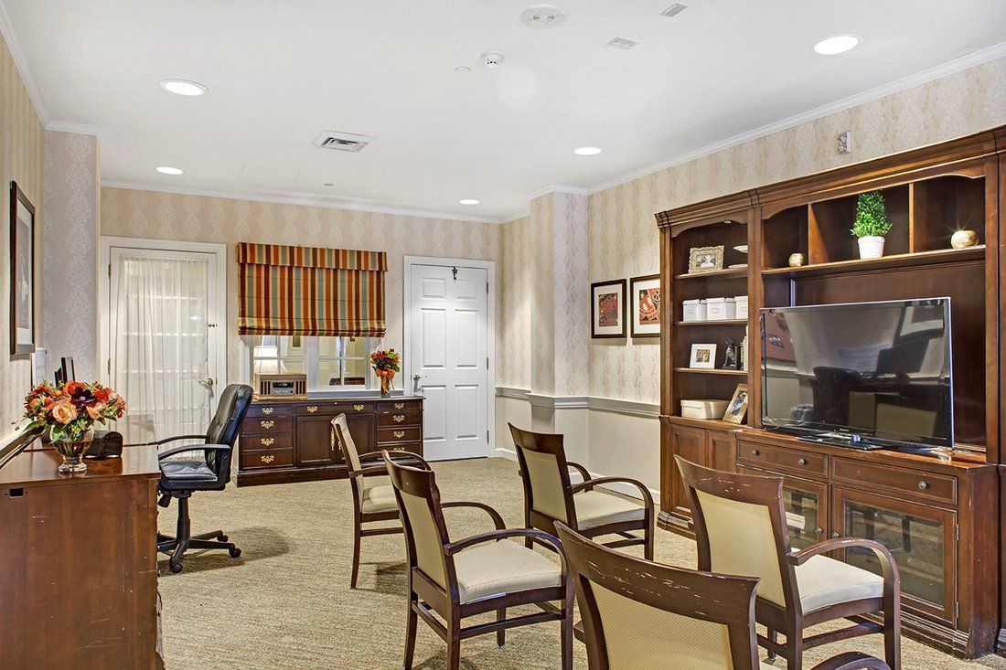 A well-furnished office space with chairs, a desk, and a bookshelf.