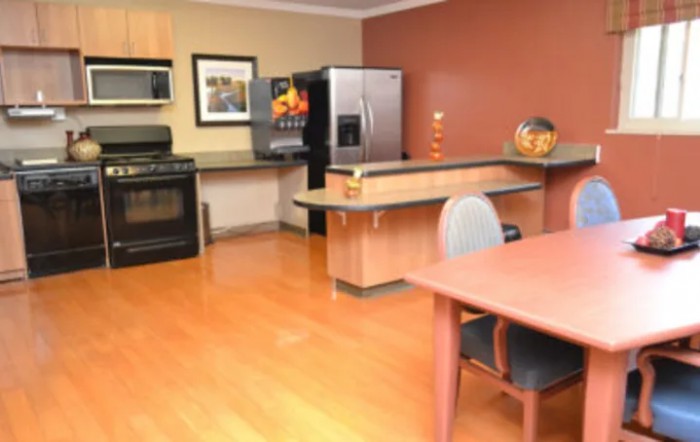A modern kitchen and dining area with stainless steel appliances and wooden flooring.