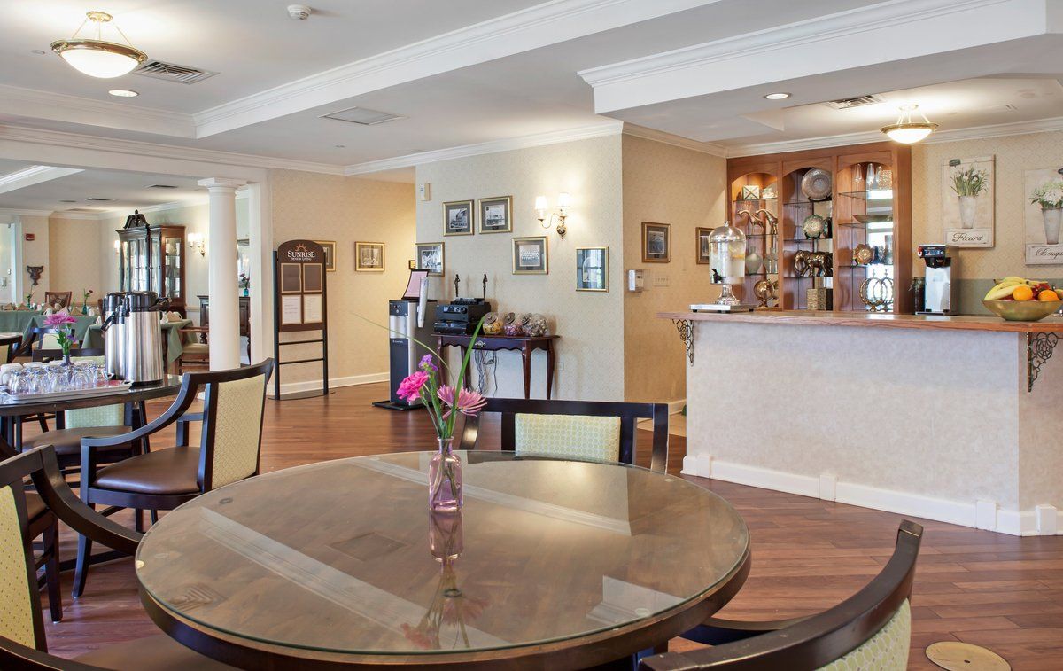 Cozy dining area with a round table, chairs, and floral centerpiece in an inviting restaurant setting.