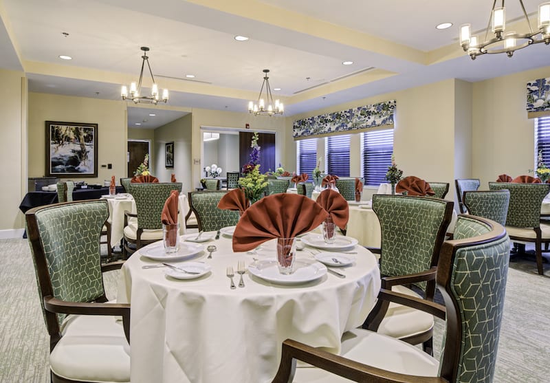Elegant dining room with neatly arranged tables and decorative napkins.