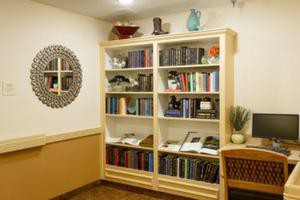 A cozy reading nook featuring a well-organized bookshelf adorned with various books and decorative items.