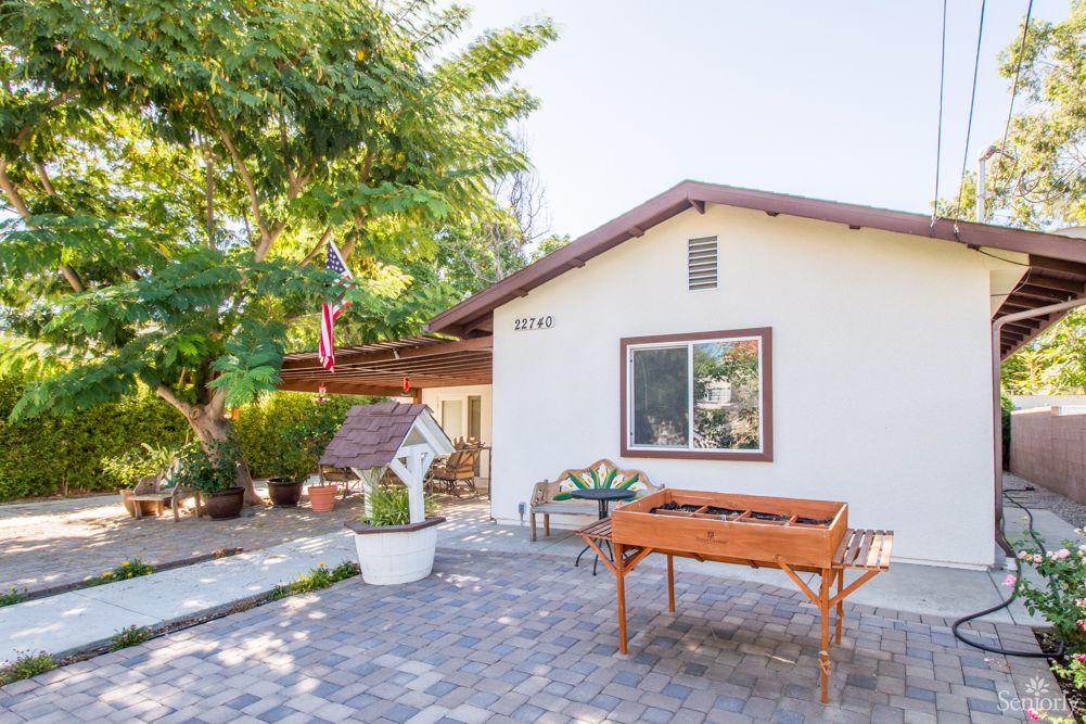 A quaint house with a well-kept garden and patio area.