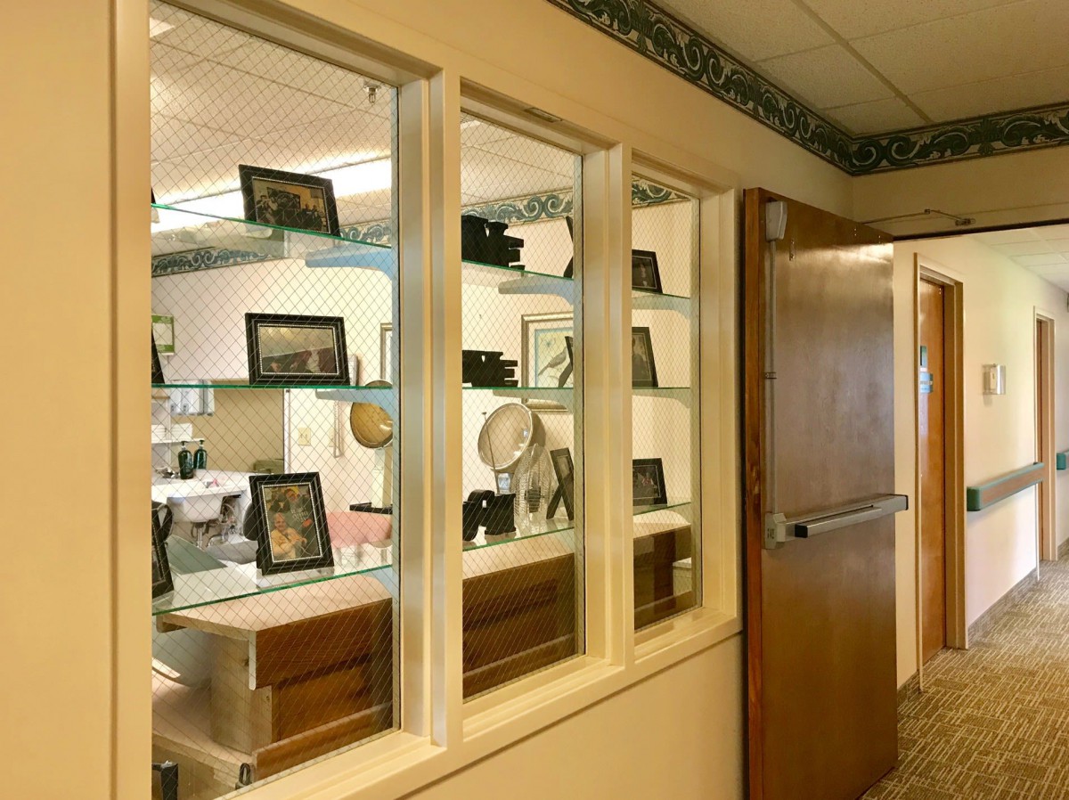 An interior view featuring a display window with shelves holding framed photos and decorative items.