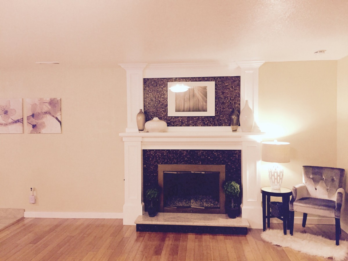 A cozy living room with a central fireplace, adorned with elegant decor and soft lighting.