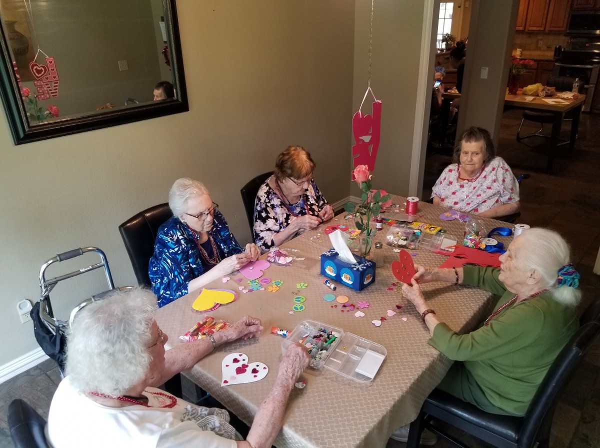 A group of seniors engaging in an arts and crafts session around a table.
