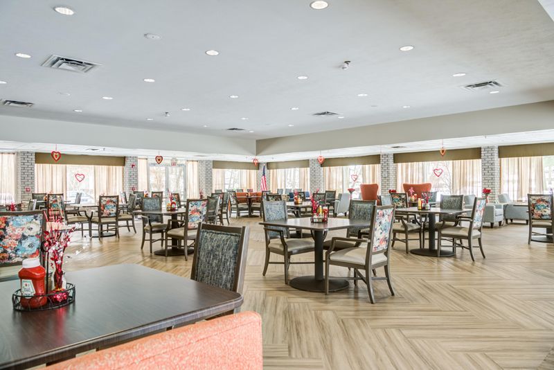 A spacious and well-lit dining area with neatly arranged tables and chairs, featuring elegant interior design.