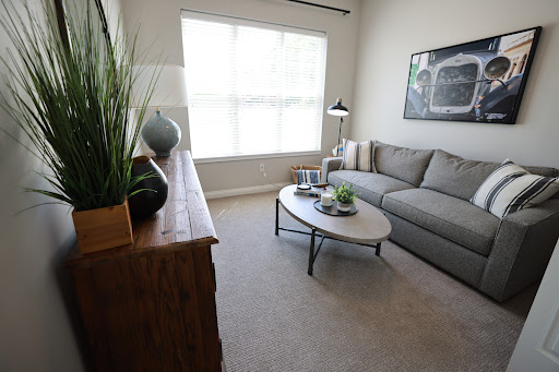 A cozy modern living room showcasing a comfortable sofa, stylish coffee table, and ample natural light.