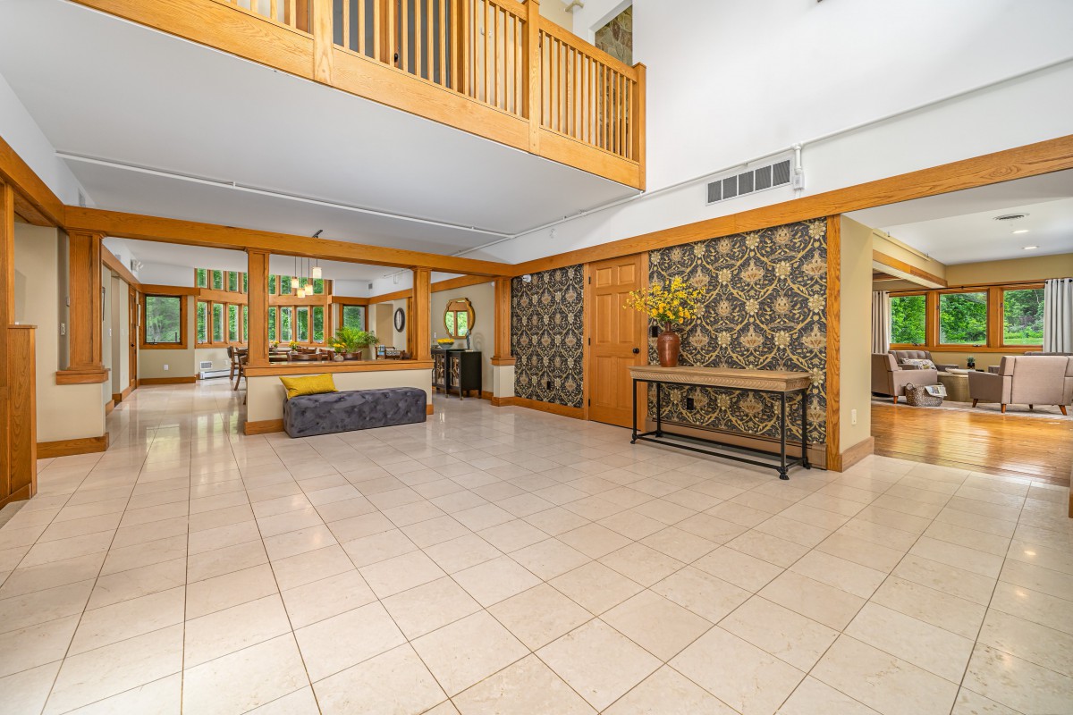 A modern and spacious lobby with tile flooring, wooden accents, and decorative wall panels.