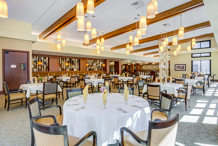 A spacious dining area with elegantly arranged tables and warm lighting.