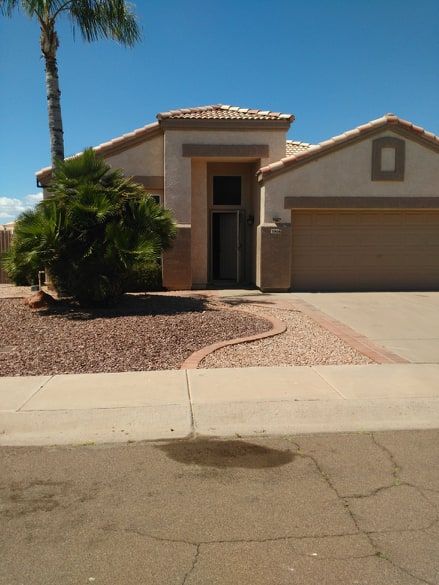 A suburban house with a large garage and desert landscaping.