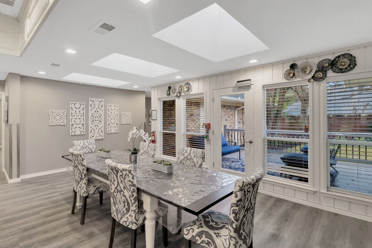 A stylish dining room with patterned chairs and abundant natural light.
