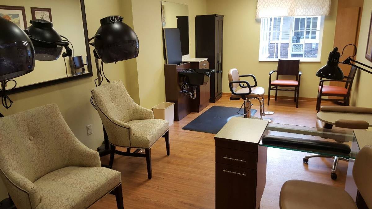 A cozy hair salon interior with styling chairs and a waiting area.