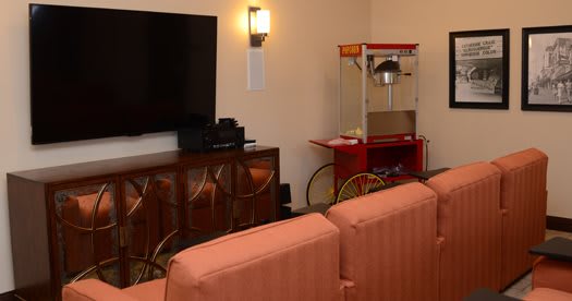 A cozy home theater setup with a large television, popcorn machine, and comfortable seating.