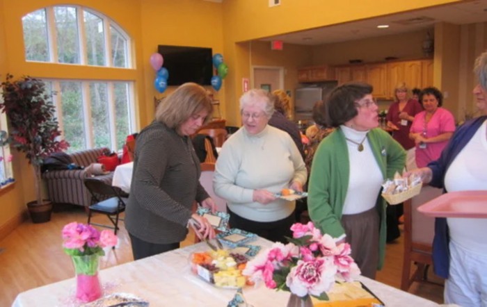 A group of women enjoying a social gathering in a brightly decorated room.