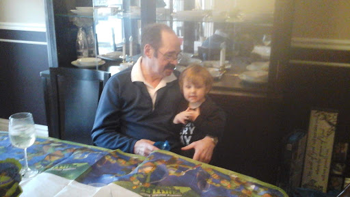 A heartwarming moment shared between a man and a child at a cafe.