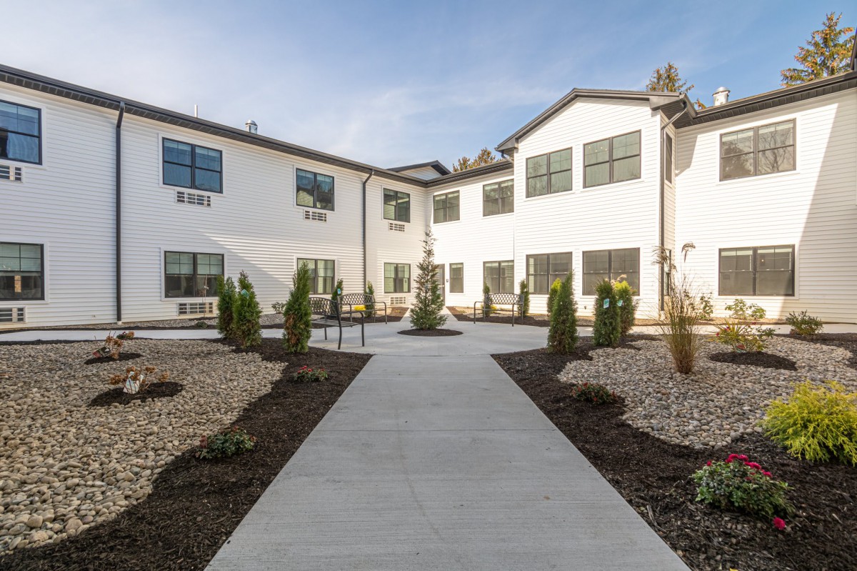 Modern residential building with a landscaped pathway.