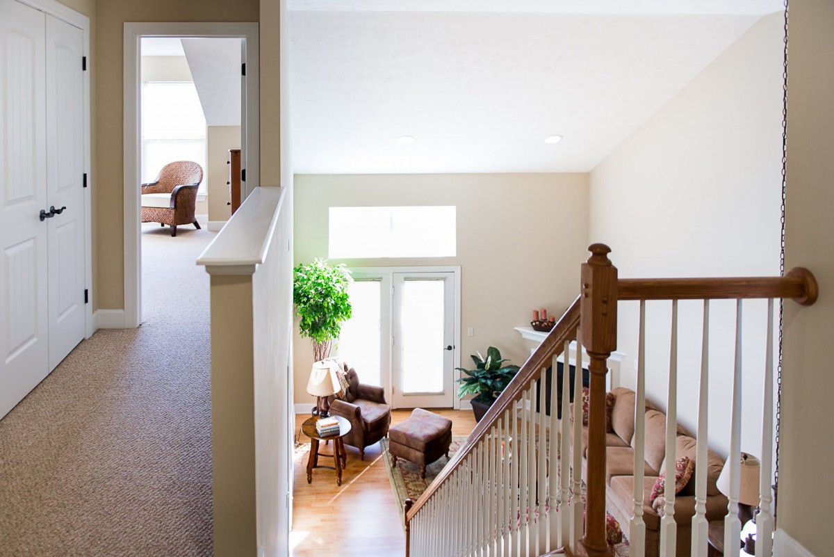 A bright and airy living room featuring a hardwood floor, comfortable seating, and natural light streaming through large windows.